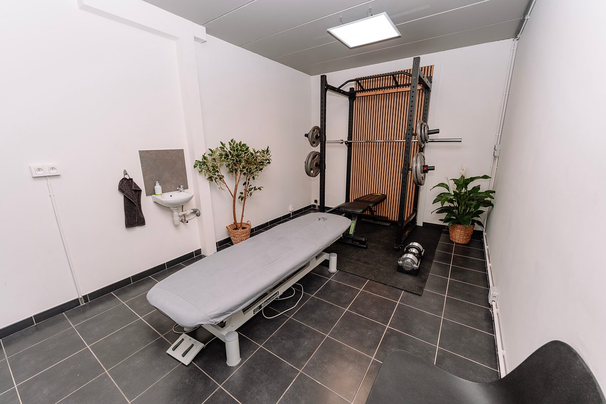 La salle de soin : table de traitement, lavabo et matériel de musculation