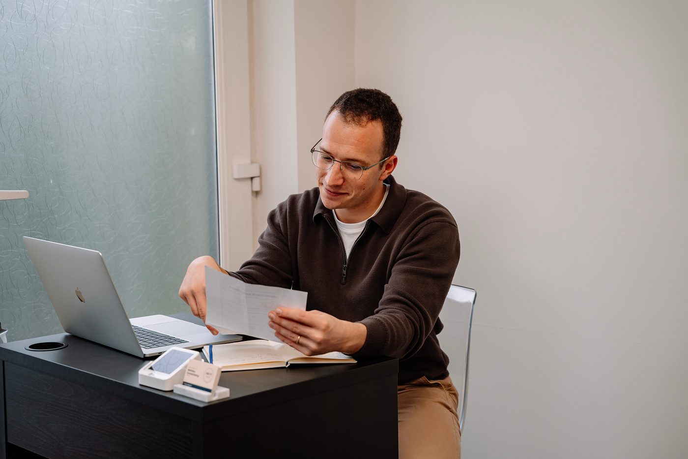 Mathieu à son bureau, en train de lire un document